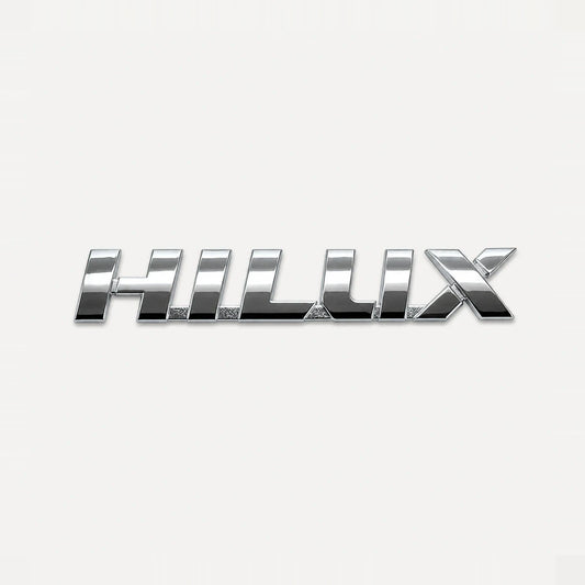 Emblema Toyota Hilux Linea Nueva 2016-2025. [IRP-CATALOG:INSI029-1-C.webp:fe25b3efc8b8f1d4]